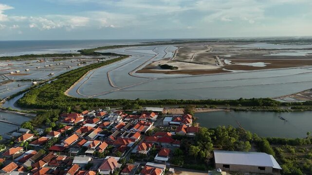 Aerial View of Mangrove Forest, Traditional Salt Pond near the beach, and Coastal Residential Area in Indonesia