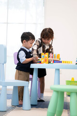 Little boy and girl playing with toys together in the playroom