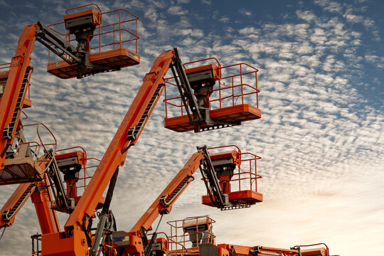 Articulated boom lift. Aerial platform lift. Telescopic boom lift against blue sky. Mobile construction crane for rent and sale. Maintenance and repair hydraulic boom lift service. Crane dealership.