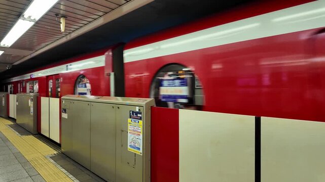 Red train in subway station platform.