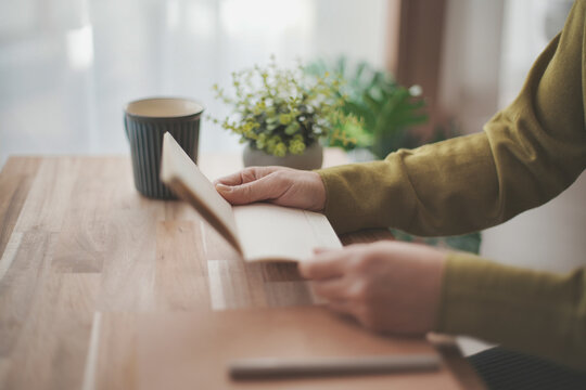 通帳を持つ女性の手元