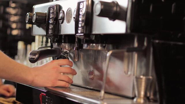 Close-up of a professional espresso coffee machine brewing fresh dark coffee in a modern cafe.