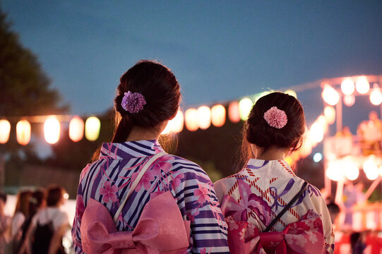 浴衣の帯と髪飾りが美しい女性二人の後ろ姿