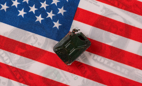 A gasoline canister against the backdrop of the US flag and US dollar bills.