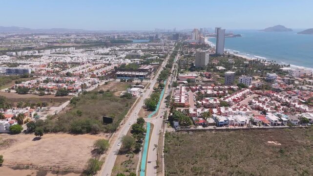 Vista aerea de zona urbana costera, mostrando una avenida transitada con el mar en el horizonte, mostrando arquitectura urbana cerca del mar