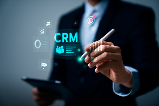Business professional using tablet and stylus with CRM interface icons, showing customer data management, communication tracking, and sales performance monitoring for digital business strategy
