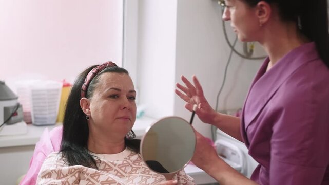 Facial correction. Beauty treatment. Cosmetologist drawing lines on woman face before plastic procedure in professional salon.