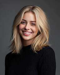 Fototapeta premium Headshot of a studio portrait photograph of a beautiful blonde woman wearing a black sweater, smiling and looking at the camera
