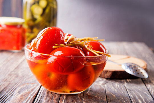 Assortie Jars of Marinated vegetables picles tomato on a wooden background
