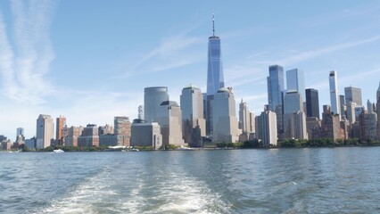 Fototapeta premium New York City Manhattan Downtown Financial District skyline, World Trade Center tower from ferry boat to New Jersey, United States of America. River waterfront urban cityscape with skyscraper building