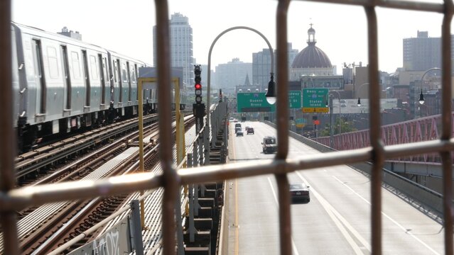 Williamsburg Bridge in Brooklyn, New York City United States. Transport metallic bridge pedestrian path near Marcy Av subway station and Domino park. Queens and Bronx road traffic sign, metro train.