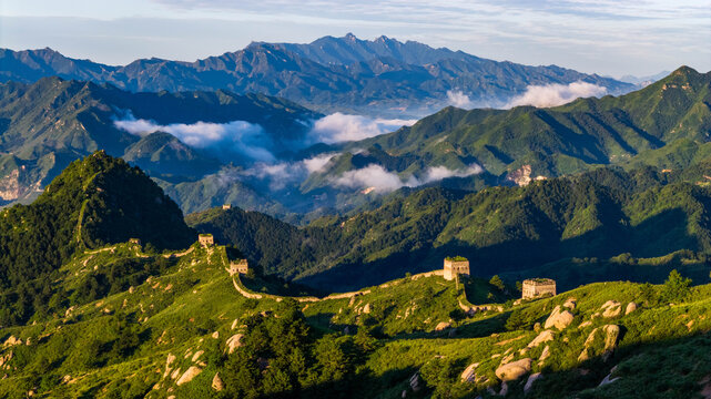 Morning view of the Great Wall in Laiyuan, Hebei Province, China, winding across green mountain ridges under soft light.