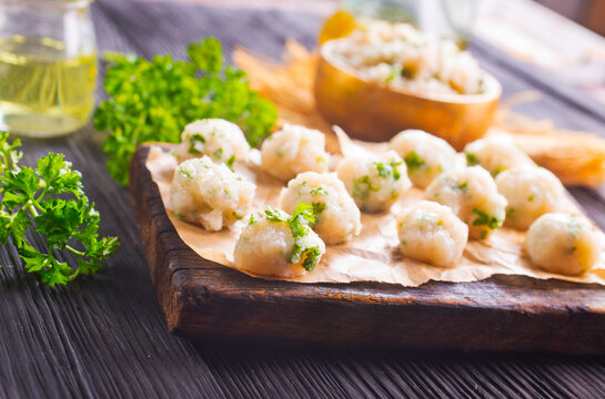 raw chicken balls on wooden board