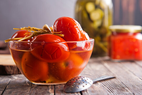 Assortie Jars of Marinated vegetables picles tomato on a wooden background