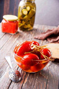 Assortie Jars of Marinated vegetables picles tomato on a wooden background
