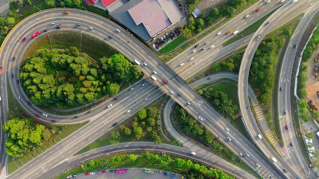Top Down Drone View of Highway Interchange with Circular Flyover and Traffic. Modern transportation infrastructure with flyovers, road junctions and traffic flow in a metropolitan environment.