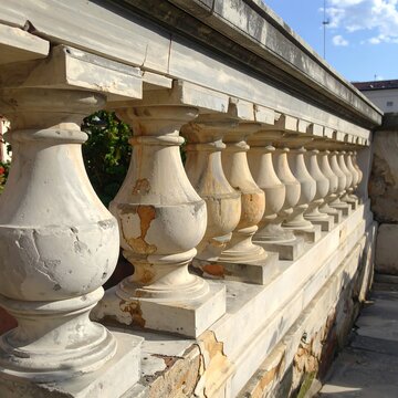 Weathered stone balustrade with chipped ornate balusters