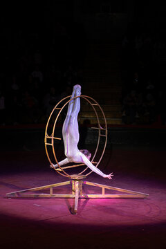 A teenage girl performs an acrobatic act on a circus ring. Concept is that children are involved in sports and circus arts