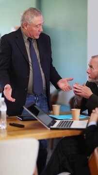 Mature male leader, trainer talking to group of people, brainstorming, discussing ideas in auditory
