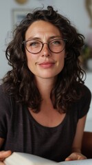 Fototapeta premium Woman with glasses, curly hair, and a contemplative expression.