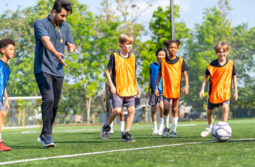 Obraz premium Coach walk and point to the position to kick the soccer ball during practice in the field for the competition with day light.