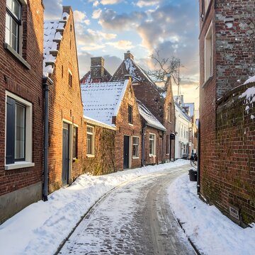 Snowy narrow street with old brick houses