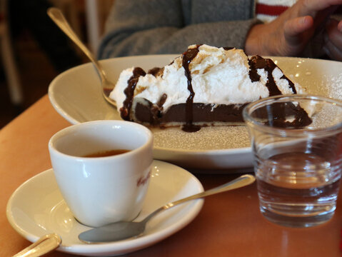 Fetta di torta al cioccolato con panna ordinata in una rinomata pasticcieria di Torino