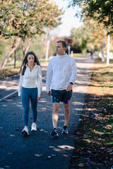 Obraz premium Couple walking on park path for fitness lifestyle