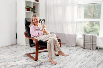 Fototapeta premium Woman sitting at white home with Dog