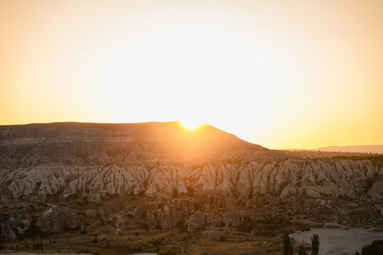 Amazing sunset over Cappadocia mountains, Red Valley in Turkey. View of Goreme National Park, sun rays over unique rock formations, volcanic landscape. Travel, nature heritage, tranquility concept