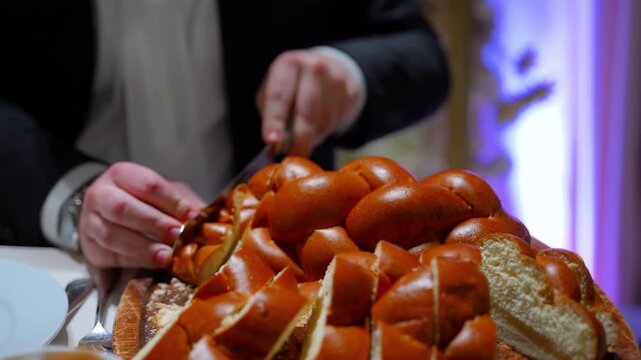Traditional Jewish wedding ceremony moment with challah bread being cut and served.