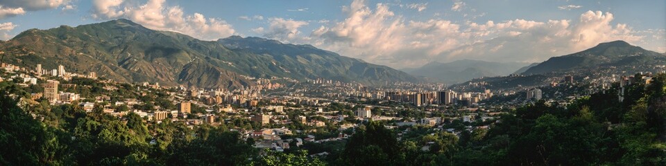 Fototapeta premium City sprawls across rolling green hills
