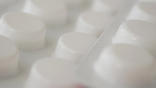 White round medicine pills in blister pack macro shot showing texture and pharmaceutical form.