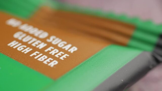 Macro shot of health food bar packaging with focus on gluten free and high fiber labeling.