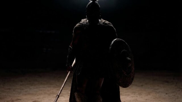 Powerful gladiator standing alone in dramatic arena shadows wearing bronze armor and holding sword and shield in tense cinematic atmosphere of ancient battle