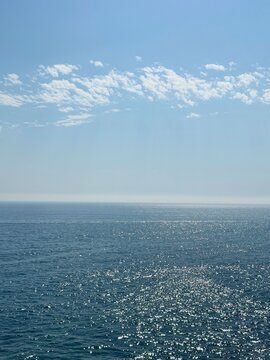 Blue glittering sea and sunny sky vertical.