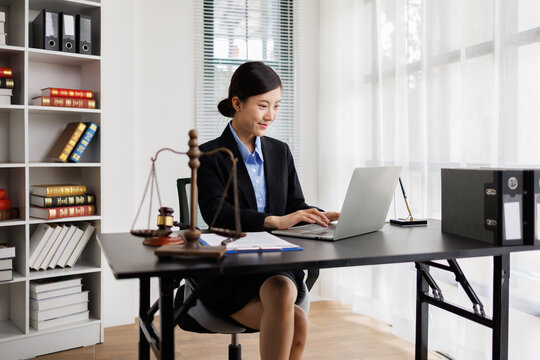 Female lawyer working on laptop in law office