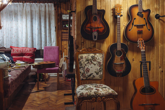 Old jazz acoustic guitars on the wooden wall in the room