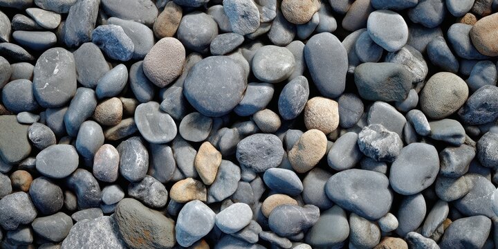 The pebbles on a coastal shore displaying smooth rounded gray stones in natural pattern