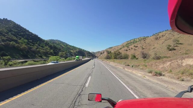 Big rig POV driving on a multi-lane mountain highway with concrete barrier
