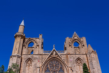 Obraz premium The stunning exterior of Lala Mustafa Pasha Mosque (formerly St. Nicholas Cathedral) in Famagusta, Northern Cyprus, showcasing its impressive Gothic architecture, pointed arches, and detailed stonewor