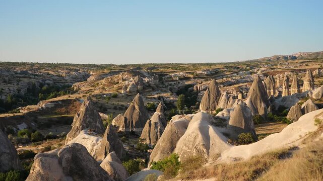 Stunning sunset over Cappadocia with fairy chimneys and Goreme village. UNESCO World Heritage site, volcanic rock formations, Turkish landscape, Anatolia tourism and nature heritage concept