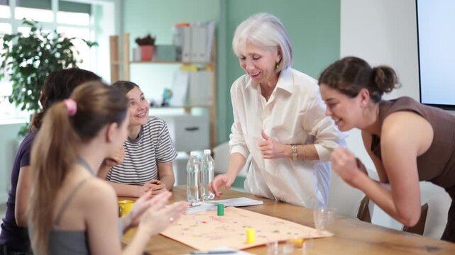 Focused female participants of different ages playing tabletop game in classroom