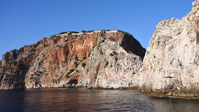 Ancient Alanya Castle walls on high rocky cliffs above Mediterranean sea. Turkey historical heritage, coastal fortress, nautical travel, nature landscape concept in summer day, coastal exploration