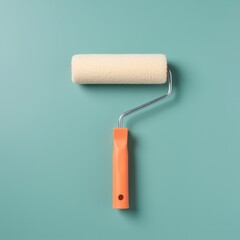 Obraz premium Paint roller with plush fiber cover and ergonomic orange handle isolated on a teal background with copy space for hardware store catalog or home renovation DIY project
