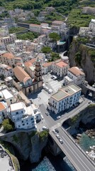 Fototapeta premium A vibrant coastal town is seen from above with buildings on cliffs by the sea under clear skies during summer