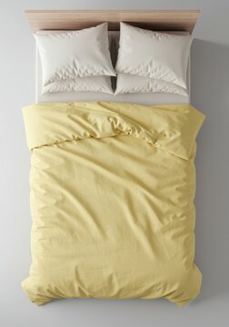Single bed with pale yellow duvet and white pillows on a grey floor from a top down view for a home interior bedding catalog with copy space