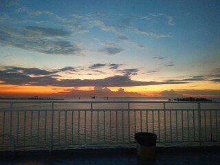 Fototapeta premium Dramatic Sunset View from Fery Ship Deck with Ocean Horizon