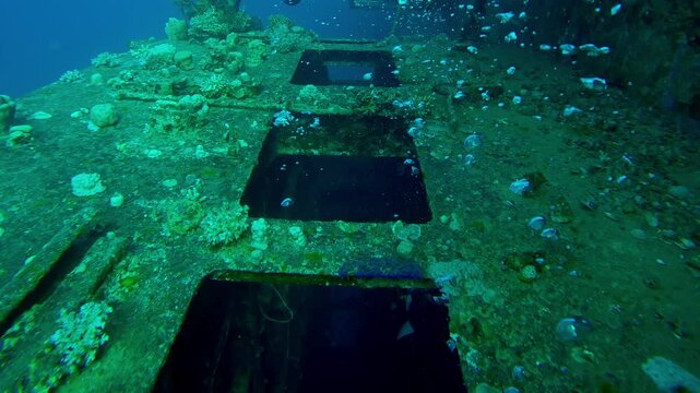 Close-up of air bubbles from scuba divers rising from windows of coral-covered wheelhouse of Salem Express ferry, Wreckship in Red Sea, Slow motion, Details of sunken ship
