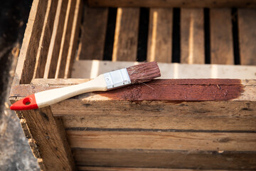 Painting Wooden Crate with Brush Applying Protective Wood Coating Outdoors
